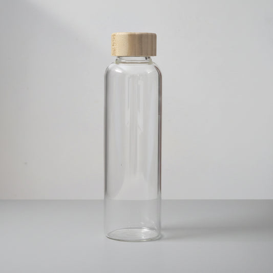 Clear glass bottle with wooden cap on a white surface