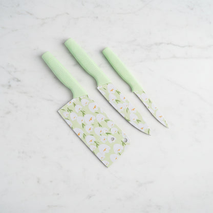 Three knives with floral-patterned covers on a gray background
